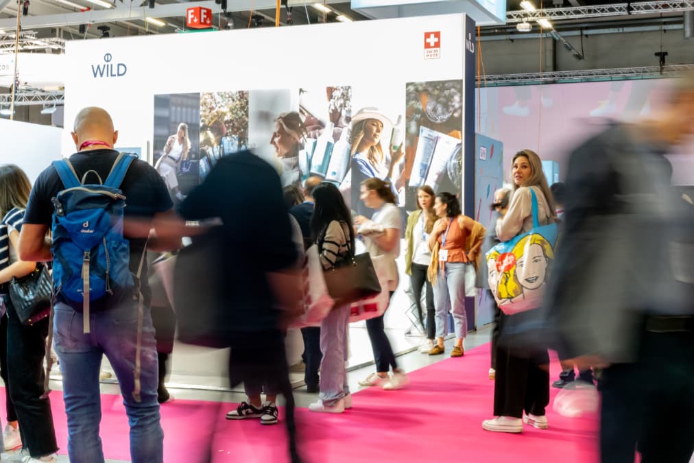 Besucher am pinken Messeboden der Dental Bern